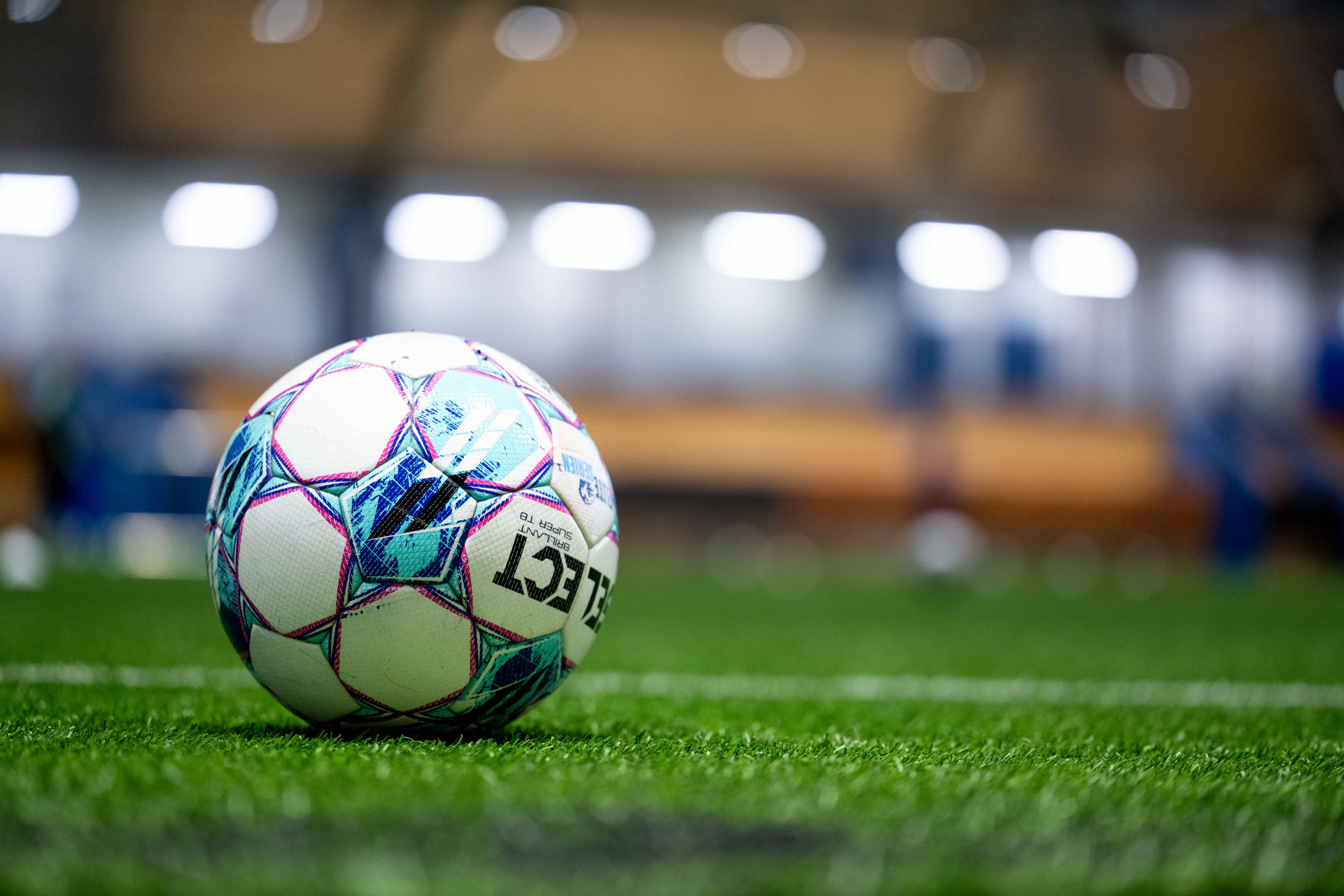 Foto: Norsk Tipping Fotball som ligger på kunstgress.